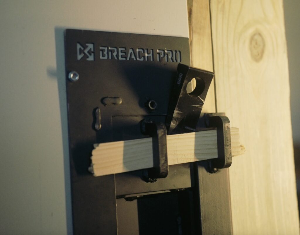 Modular breaching door insert installed in a standard door frame, showing realistic lockset engagement and repeatable training construction for mechanical breaching drills.