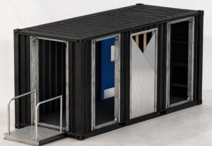 Front three-quarter view of the BP-MBTC-20-C1 Mobile Breaching Training Center showing three adjustable breaching frames, integrated wall breach section, and containerized tactical training platform for mechanical, ballistic, and explosive breaching operations.