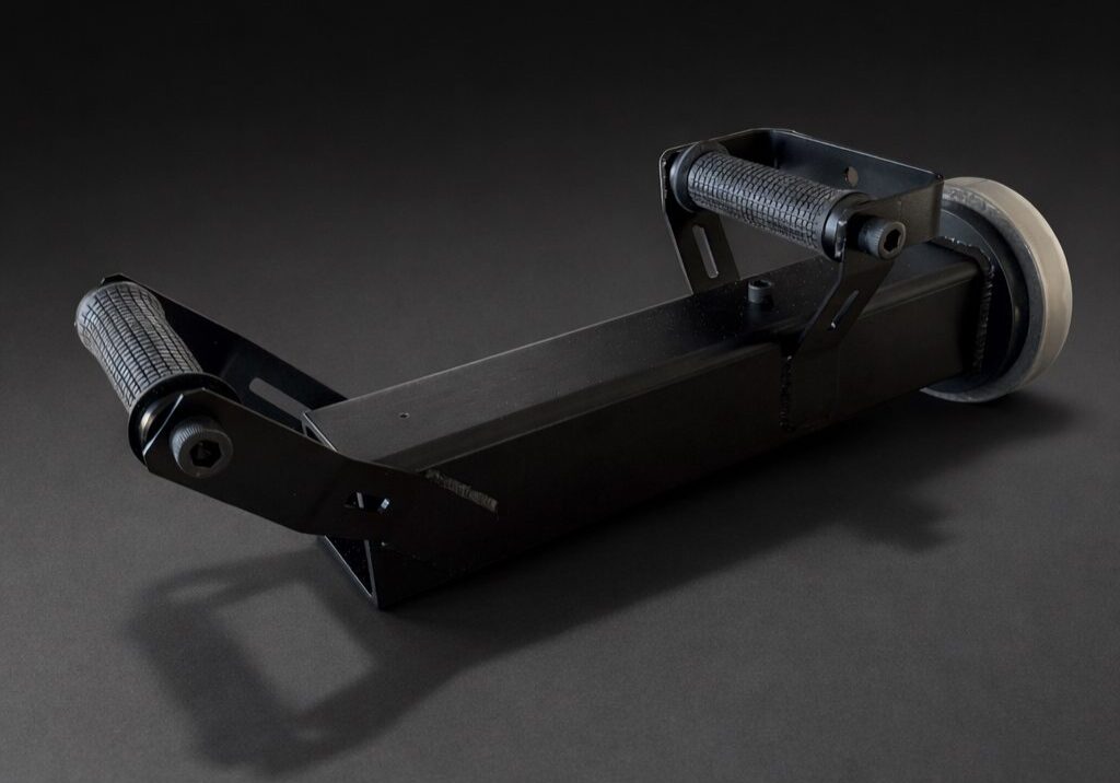A black camera film winder on a dark background.